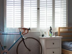 blue and black bicycle beside white wooden drawer