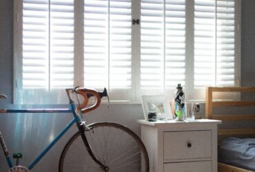 blue and black bicycle beside white wooden drawer