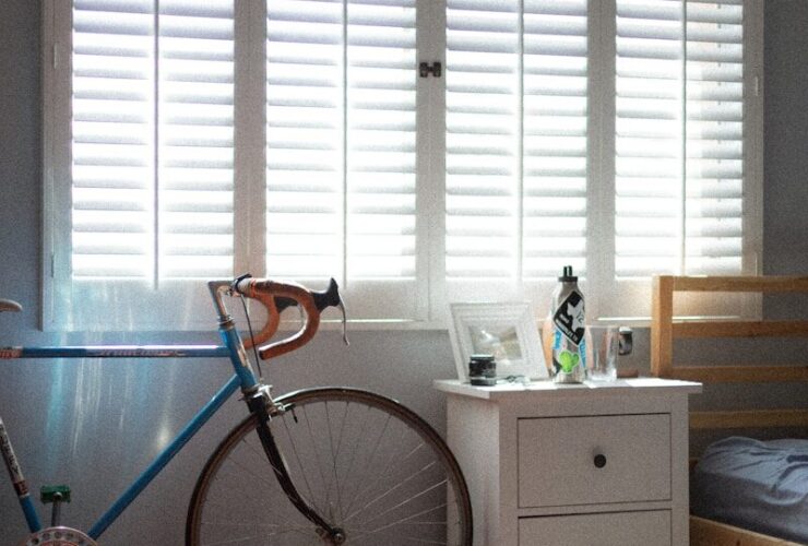 blue and black bicycle beside white wooden drawer