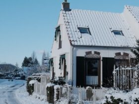 A snow-covered house on a clear winter day.