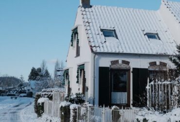 A snow-covered house on a clear winter day.