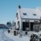 A snow-covered house on a clear winter day.