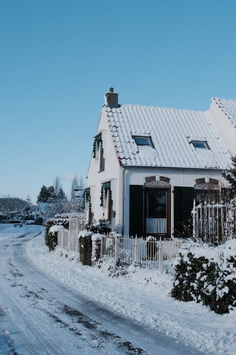 A snow-covered house on a clear winter day.