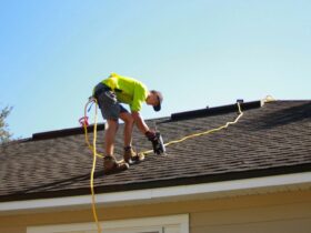 a man working on a roof with a power drill