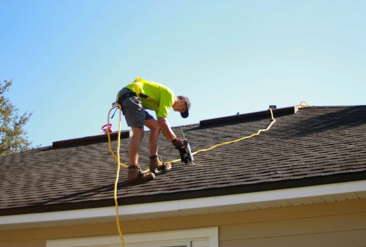 a man working on a roof with a power drill