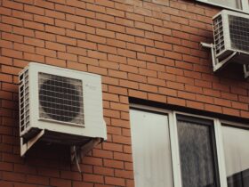 Air conditioners are attached to a brick building.