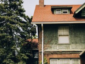 a house with a red roof and a tree in front of it