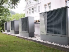 Four industrial air conditioning units lined up outside building