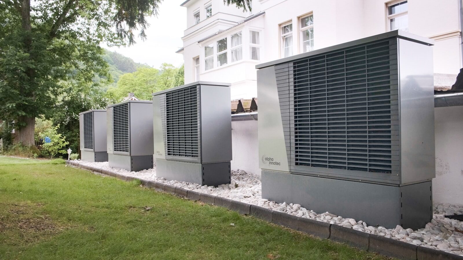 Four industrial air conditioning units lined up outside building
