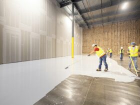 Workers painting a large industrial floor white