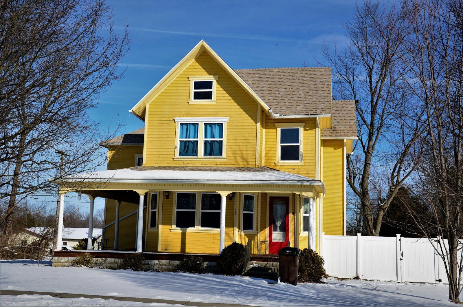a yellow house with snow on the ground