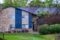 Apartment building with stone, blue siding, and green lawn