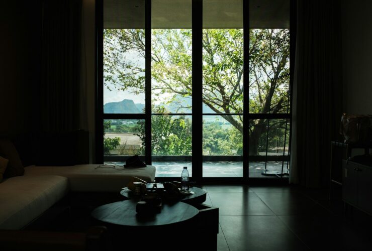 Dark room with large window and nature view