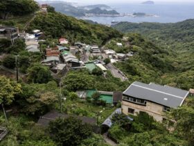 A hillside village overlooks a bay with distant islands