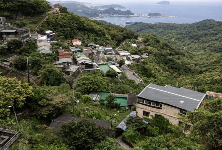 A hillside village overlooks a bay with distant islands