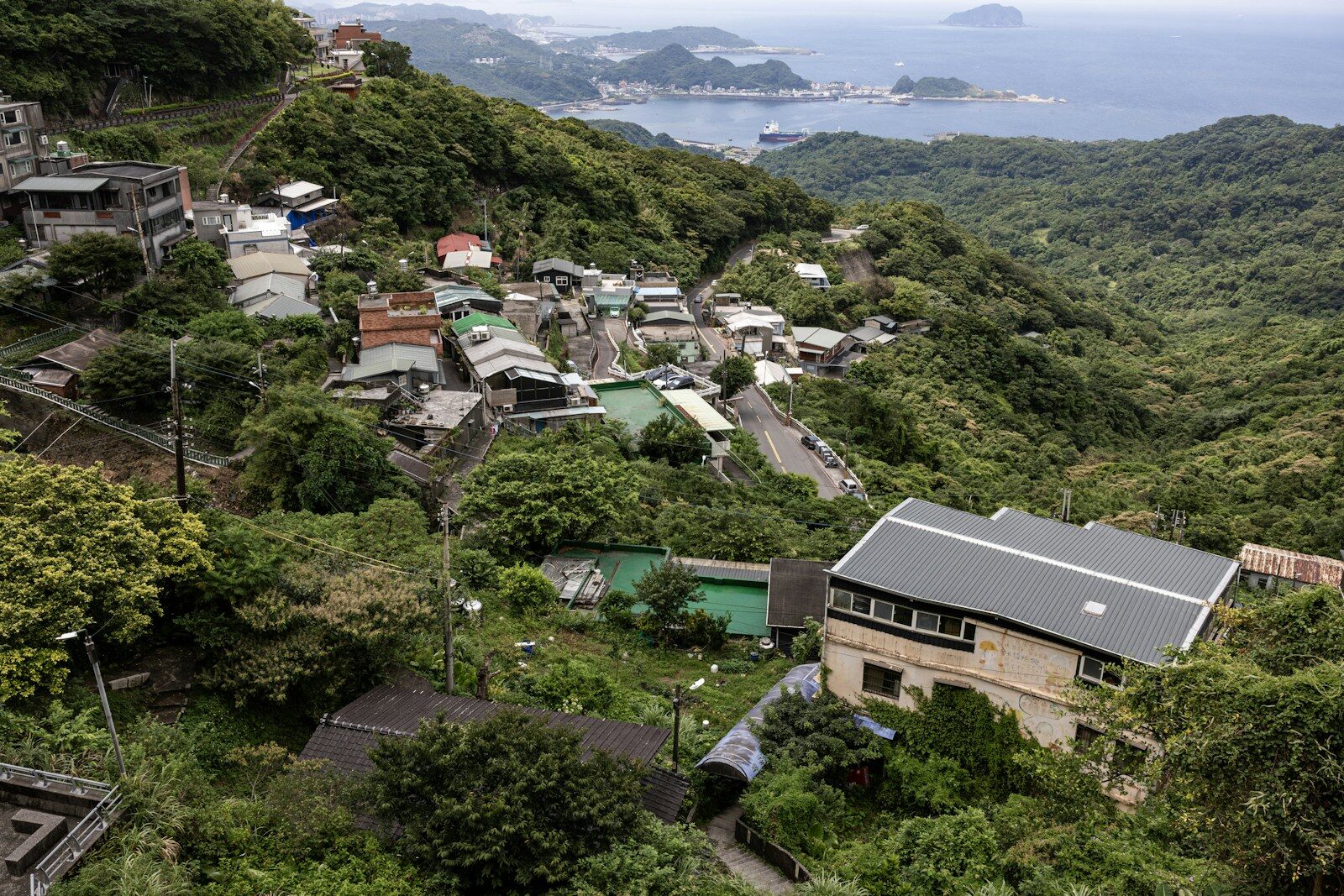 A hillside village overlooks a bay with distant islands
